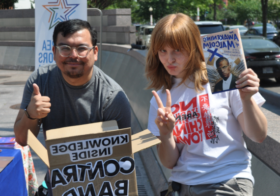 Two people holding signs. 